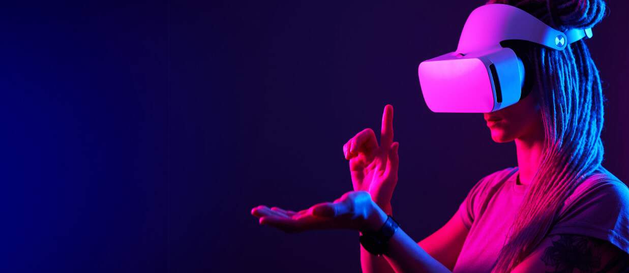 Donna che indossa un visore VR e interagisce con il mondo digitale, rappresentando le esperienze interattive create da GameThinkers.